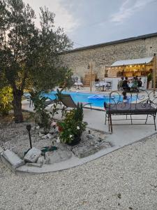 a swimming pool with a bench and some plants at Le Patio des Charentes in Sainte-Lheurine