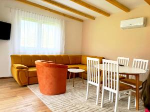 a living room with a couch and a table and chairs at Kucica na Drini MINJA in Višegrad +10 photos