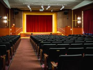 ein leerer Saal mit Stühlen und einem roten Vorhang in der Unterkunft Neptune, an Ash Hotel in Providence