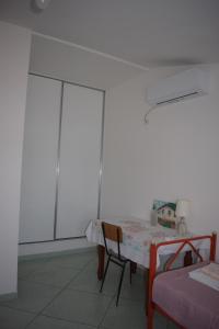 a room with a table with a chair and a bed at Ulza Lake Escape in Ulëz