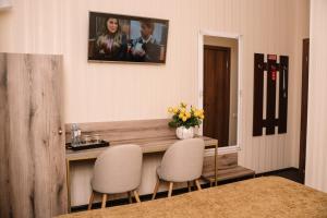 a room with two chairs and a table with a vase of flowers at Шляпа in Dnipro