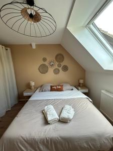 a bedroom with a bed with two towels on it at La parenthèse in Artolsheim