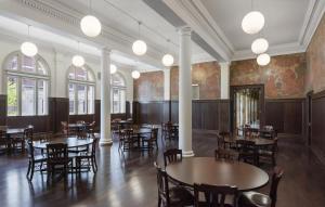 ein Esszimmer mit Tischen und Stühlen und Gemälden an den Wänden in der Unterkunft Neptune, an Ash Hotel in Providence