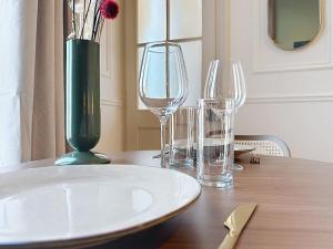 a table with three wine glasses and a vase on it at Le Studio du Chateau in Bréviandes