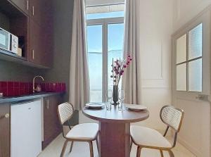 a kitchen with a table with chairs and a window at Le Studio du Chateau in Bréviandes +9 photos