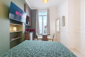 a hotel room with a large bed and a table at Le Studio du Chateau in Bréviandes