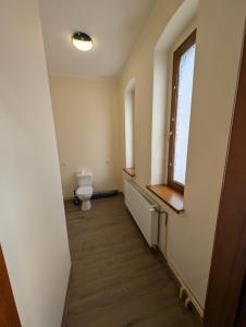 an empty bathroom with a toilet and a window at Hostel Kalinowskiego in Żary