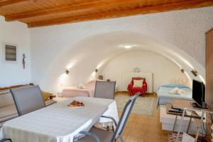 a room with a table and chairs and a tv at Traditional House in Velies in Áyios Sarándos +12 photos