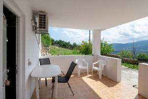 a room with a table and chairs on a balcony at Traditional House in Velies in Áyios Sarándos