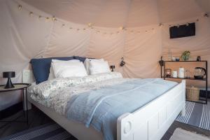 a bedroom with a bed in a tent at FLO Lofoten nature escape in Valberg