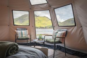 a room with two chairs and windows in a tent at FLO Lofoten nature escape in Valberg
