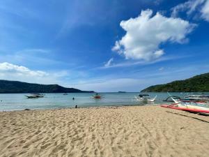 ein Sandstrand mit Booten im Wasser in der Unterkunft ACA Transient House in Nasugbu