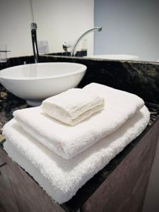 a pile of towels sitting on a counter next to a sink at C1 Suite in Las Varillas