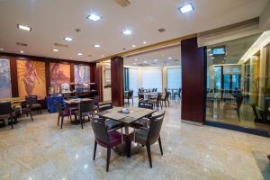a dining room with tables and chairs in a restaurant at Hotel Tiffany Milano in Trezzano sul Naviglio