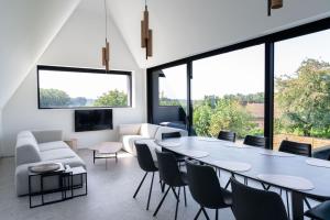 a living room with a large table and chairs at Apartment L'O Reine, B&B in Sint-Pieters-Leeuw +22 photos