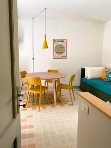 a dining room with a table and chairs and a couch at Cefalhub in Cefalù