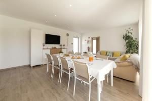 a white dining room with a white table and chairs at Terra - B&P Infinity House in São Martinho do Porto