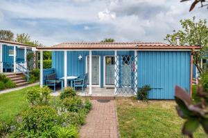a blue house with a table in a yard at Möve Aba Bungalow 66 in Rerik