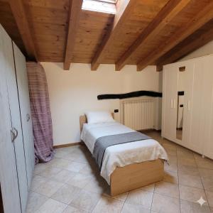 a bedroom with a bed and a wooden ceiling at L'Antico Fienile Mountain Lake Iseo Hospitality in Fonteno