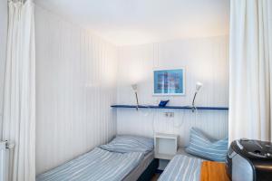 a small bedroom with a bed and a window at Möve Aba Bungalow 66 in Rerik