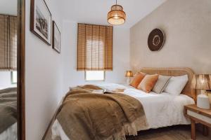 a bedroom with a bed with white sheets and orange pillows at Impressive beachfront home in Calafell