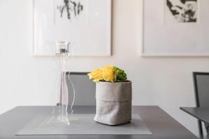 a vase with a yellow rose in it on a table at Zollhaus - Doppelzimmer in Endingen