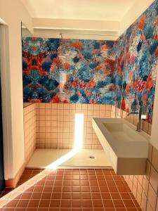 a bathroom with a sink and a painting on the wall at Cefalhub in Cefalù +40 photos
