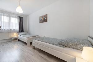 a white bedroom with two beds and a window at Ferienhaus Heide in Bad Fallingbostel
