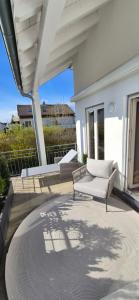 a patio with a white chair and a table at CASAMA am See in Langenargen