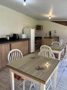 a kitchen with a table and chairs and a refrigerator at Pousada Centro in Gramado