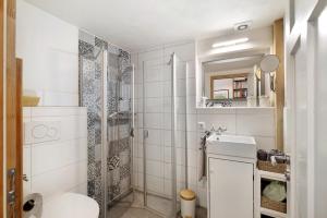 a white bathroom with a shower and a toilet at Ferienwohnung Zur Alten Scheune in Balingen +18 photos