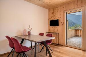 a dining room with a table and chairs and a window at Naturapartments Alpreid Zirbe in San Pancrazio dʼUltimo