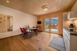 a kitchen and dining room with a table and chairs at Naturapartments Alpreid Zirbe in San Pancrazio dʼUltimo