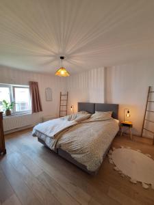 a bedroom with a large bed and a ceiling at Ma maison de famille in Saint-Hubert