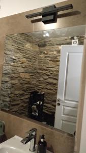 a bathroom mirror with a stone wall behind a sink at AegeanDeepBlue2 in Apróvaton +38 photos