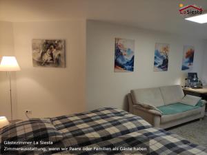 a bedroom with a bed and a chair and pictures on the wall at Gästezimmer La Siesta in Ötisheim