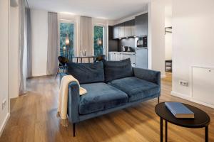 a living room with a blue couch and a kitchen at Egge Resort 7f mit Whirpool u Sauna in Altenbeken