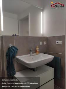a bathroom with a white sink and a mirror at Gästezimmer La Siesta in Ötisheim +22 photos