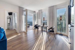 a living room with a table and chairs and windows at Egge Resort 7f mit Whirpool u Sauna in Altenbeken