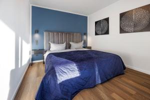 a bedroom with a bed with a blue comforter at Egge Resort 7f mit Whirpool u Sauna in Altenbeken