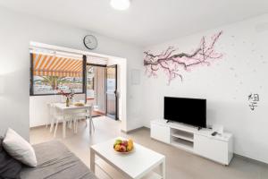 a living room with a television and a table with a bowl of fruit at Casa Isabel eccezionale Vista Mare in Mogán