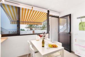 a dining room with a white table and a window at Casa Isabel eccezionale Vista Mare in Mogán