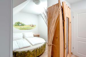 a bedroom with a bed and a painting on the wall at Ferienwohnung Heuschober in Neuendorf am See