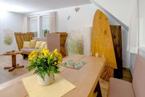 a living room with a table with a vase of flowers at Ferienwohnung Heuschober in Neuendorf am See +8 photos