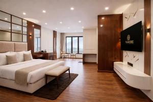 a hotel room with a large bed and a desk at Valmere Chery Blossom Suites in Shillong