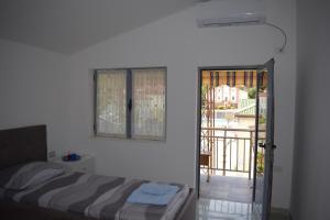 a bedroom with a bed and a sliding glass door at Ulza Lake Escape in Ulëz
