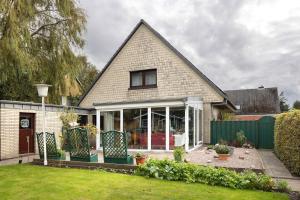 a house with a large window and green fence at Haus Stoldt in Meldorf