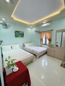 a bedroom with two beds and a red table at Sơn Tùng Hostel in Cat Ba +7 photos