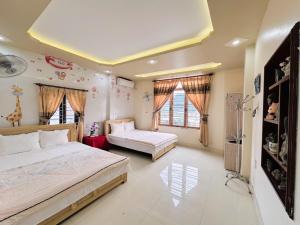 a bedroom with two beds and two windows at Sơn Tùng Hostel in Cat Ba