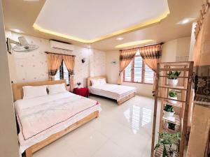 a bedroom with two beds and two windows at Sơn Tùng Hostel in Cat Ba